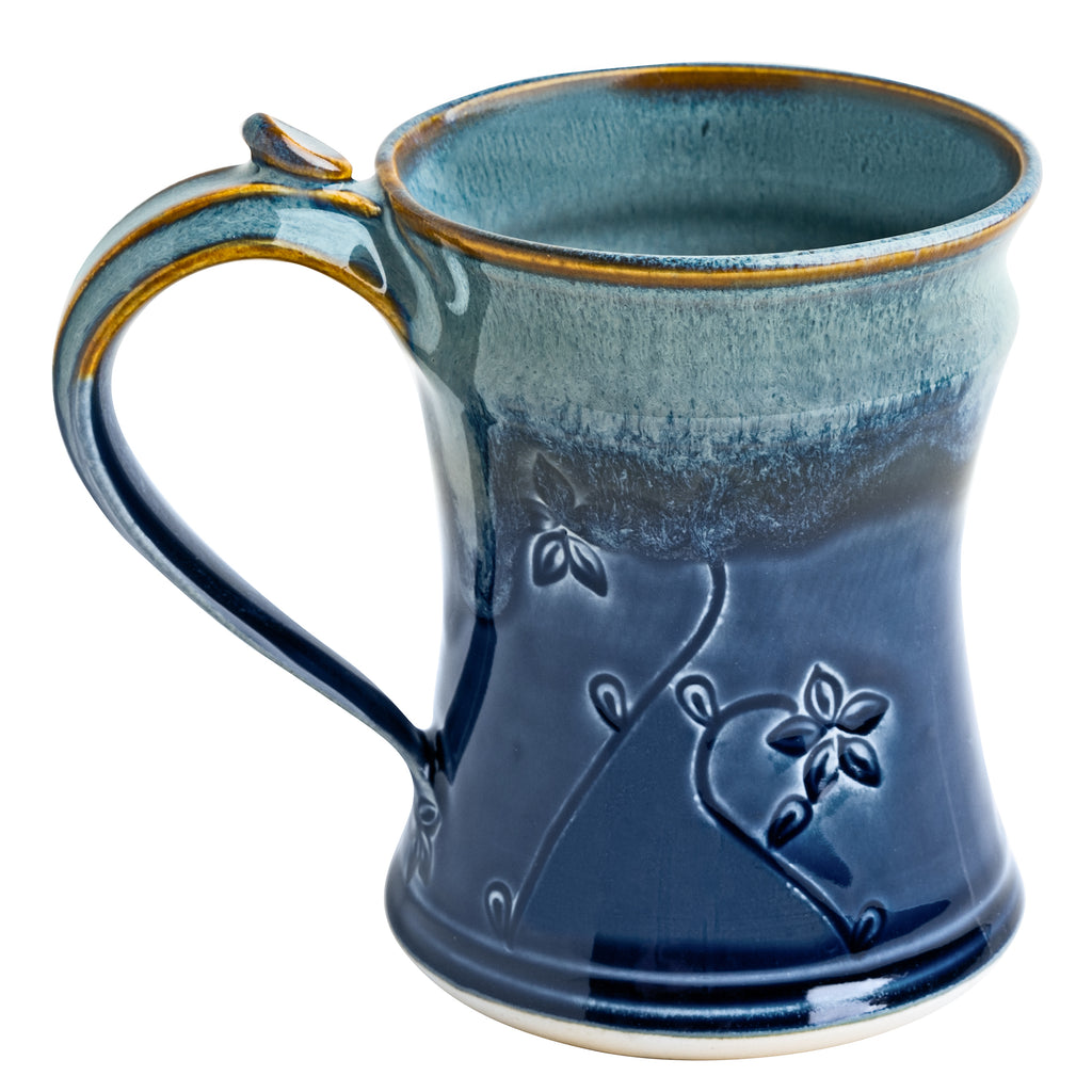 Handmade in USA by local artisan, ceramic 8oz mug in blue featuring an intricate floral pattern detail. Microwave/dishwasher safe.